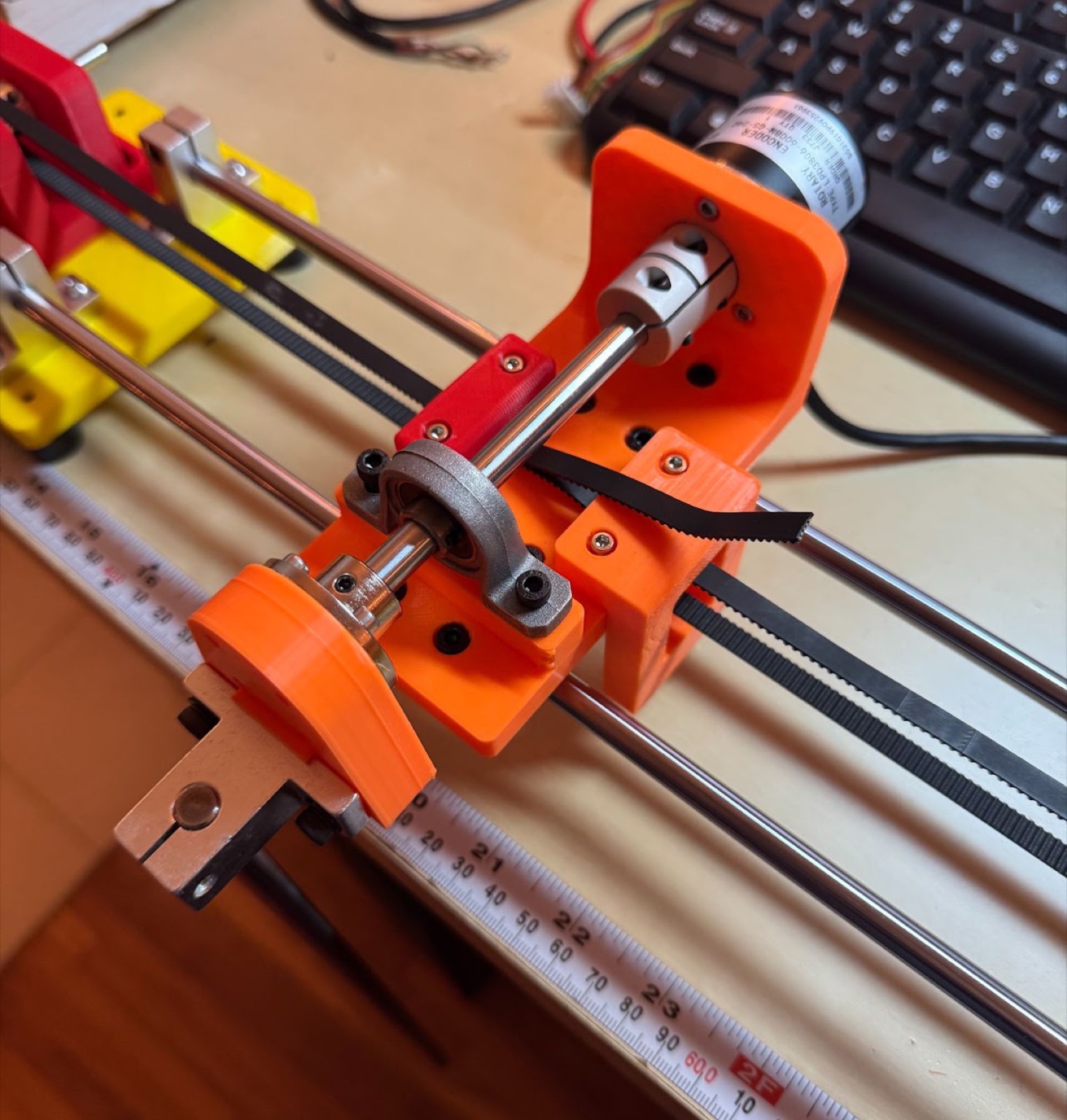 Carriage assembly on the linear rails showing the encoder, drive belt, and pendulum shaft